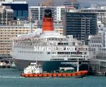 ID 1577 QUEEN ELIZABETH 2 (1969/70327grt/IMO 6725418) berthed at the Princes Wharf Cruiseship Terminal in Auckland, NZ during a 36 hour stop-over during her 2004/5 World Cruise. The bunkering barge TOLEMA 1...